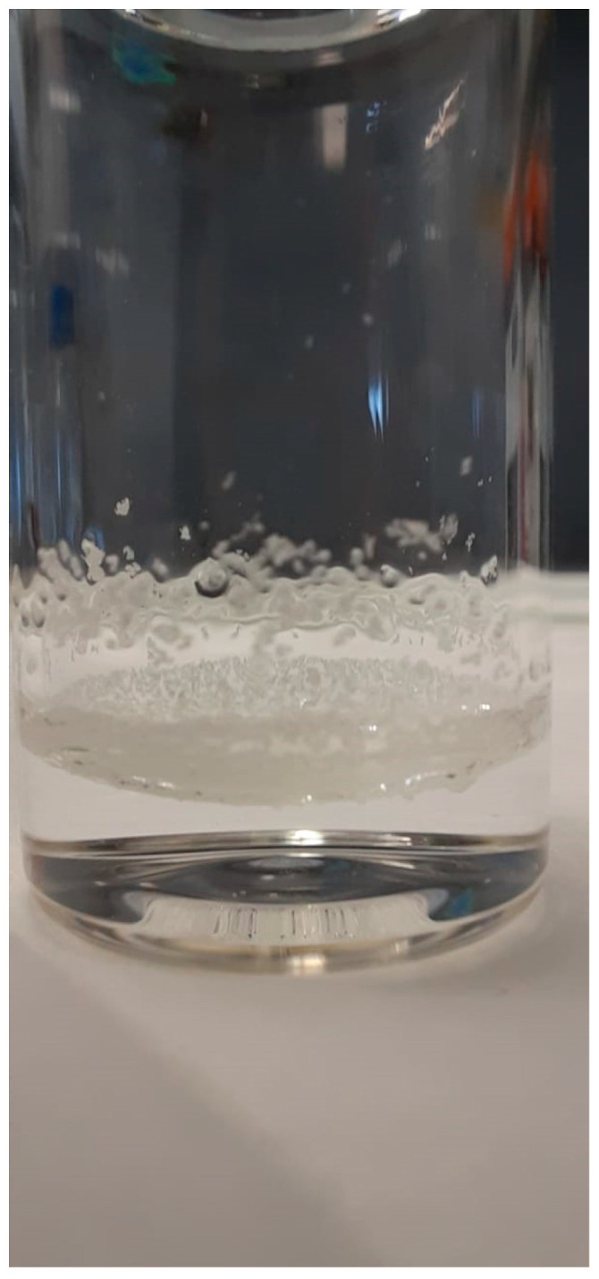 Photograph of CBD (20 mg/mL) dissolved in purified water. It can be clearly seen that the CBD does not dissolve in water. Rather, it sticks as a gel-like substance on the glass walls.